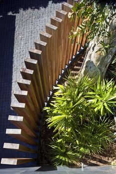 a wooden fence next to some plants and rocks