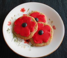 three cookies with red icing on a plate