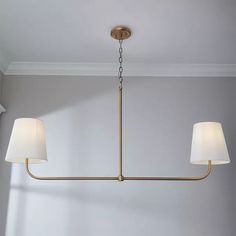 a light fixture hanging from the ceiling in a room with white walls and two lamps