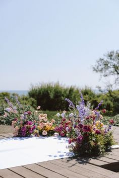 some flowers are sitting on a wooden deck