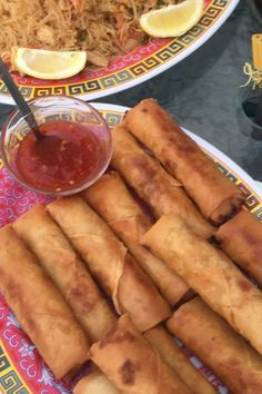 some food is sitting on a plate and next to a bowl with sauce in it