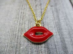 Gold and red lips necklace, with matching brass chain and closes with a lobster claw clasp.Pendant is 13mm long, 18mm wideChoose your length of chain during checkout.I package each piece of jewelry in a colorful organza bag. Perfect for gift giving or a gift for yourself.Don't forget to look through the add on section to add more customized fun.https://www.etsy.com/shop/RevelryJewelryThank you fairy much. Nickel Free Red Metal Charm Necklaces, Red Brass Necklaces For Gift, Nickel-free Red Metal Charm Necklaces, Red Metal Charm Necklace With Adjustable Chain, Red Brass Necklaces As Gift, Red Nickel-free Charm Necklace For Gift, Red Pendant Charm Necklace In Metal, Red Metal Pendant Charm Necklaces, Red Nickel-free Pendant Charm Necklace