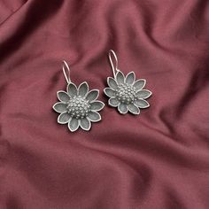 Quirky Fashions Sunflower Bugadi Earring in Silver Black Polish Brighten your look with the Quirky Fashions Sunflower Bugadi Earring, beautifully crafted in silver black polish. This unique piece features a charming sunflower design that captures the essence of nature's beauty. The versatile earring can be worn elegantly over the ear or as a delightful dangle, allowing you to express your style effortlessly. The intricate detailing of the sunflower petals adds a touch of sophistication, making i Silver Flower-shaped Metal Earrings, Sterling Silver Flower Earrings For Parties, Silver Flower Earrings With Ear Wire For Party, Silver Flower Jewelry With Oxidized Finish, Silver Oxidized Flower Jewelry, Sunflower Petals, The Sunflower, Quirky Fashion, Black Polish