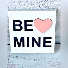 a sign that says be mine with a heart on it