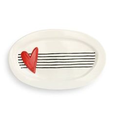 a white plate with a red heart and black stripes on the rim, against a white background