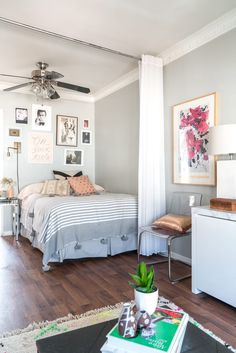 a bed room with a neatly made bed and a ceiling fan