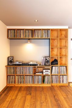 an entertainment center with wooden shelves and record players