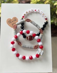 You are purchasing a beautiful set of 3 football themed bracelets. You pick your team and I will create something pretty just for you! These are perfect for GAME DAY!! ❤️🏈 All bracelets are made standard size (6.75-7"). If you need a smaller/larger size, please send me a message and I will create it for you! Thank you for looking.  All bracelets are created using a variety of different beads (glass, acrylic, etc.) Gold spacers are gold plated and non-tarnish with proper care! Football Bead Bracelet, Football Beaded Bracelets, Personalized White Bracelets For Football Season, White Team Spirit Bracelets For Game Day, Football Clay Bead Bracelets, Game Day Bracelets, Team Spirit Crafts, Themed Bracelets, Team Bracelets