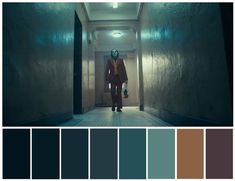 a person walking down a hallway in front of a wall with color swatches on it