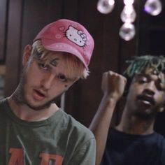 two young men standing next to each other in front of a chandelier with hello kitty on it