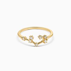 a yellow gold ring with flowers and stars on the side, set against a white background