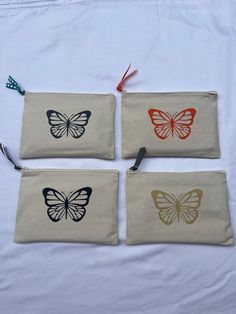 "Canvas pouch with a butterfly in heat-pressed vinyl and a ribbon on zipper. Each pouch comes with drawing paper and Cra-Z-Art markers. 9\" x 6\". Color options: orange butterfly with orange ribbon, black butterfly with zigzag black, yellow, pink, and green ribbon, beige butterfly with gray ribbon, and gray butterfly with blue polka dot ribbon." Cupcake Apron, Grey Ribbon, Orange Ribbon, Trinket Bowl, Orange Butterfly, Z Arts, Canvas Pouch, Black Butterfly, Green Ribbon