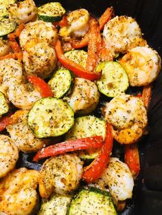 shrimp, zucchini and peppers in a skillet with seasoning on top