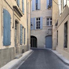 an empty street with blue shutters on the windows