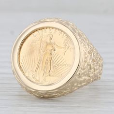 Metal: 14k Yellow Gold Ring, 22k Yellow Gold Coin Weight: 12.2 Grams  Stamps: 14k Face Height: 21.2 mm  Rise Above Finger: 5.2 mm Band / Shank Width: 2.9 mm This ring is a size 10, but it can be resized down 3 sizes for a $20 fee or up 2 sizes for a $40 fee. If you would like your ring resized, please select the appropriate fee from the listing below in order to pay the sizing fee: https://www.etsy.com/listing/781388346/ring-sizing-service-fee Each piece is thoroughly examined and refinished as needed by our professional jewelers, graded by our in-house GIA (Gemological Institute of America) Graduate Gemologist, and inspected for quality before being carefully packaged and promptly shipped. [SKU: B30587] phd 5 Dollar Gold Coin Ring, 14k Yellow Gold Engraved Ring For Commemoration, Commemorative Yellow Gold Rings Stamped 14k, Commemorative Stamped 14k Yellow Gold Ring, 14k Gold Engraved Commemorative Ring, 14k Gold Engraved Commemoration Ring, Yellow Gold Signet Ring For Commemoration, Yellow Gold Round Engraved Ring For Commemoration, Engraved Yellow Gold Ring For Commemoration