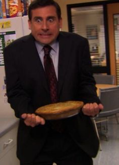 a man in a suit and tie holding a pie