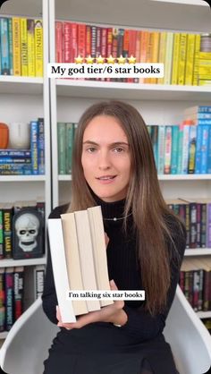 a woman holding a book in front of bookshelves with the caption my god tier 6 star books