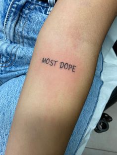 a person's arm with the word most dope tattooed on it, in black ink