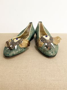 This is a pair of Italian leather shoes from Albanese Roma. They are finely crafted to resemble an elephant head. The trunk is dimensional and the details include tusks, golden ears and a blue jewel in the middle of the elephants head. The gold embossed leather portion of the shoes is very soft leather with a paisley print. The shoes are lined in gold leather and have leather soles. There is some staining on the soles of the shoes and there is a bit of discolored glue on one of the tusks. Otherw Gold Leather Shoes For Galas, 60s Shoes, Leather Jewels, Jeweled Shoes, Poodle Skirt, Italian Leather Shoes, Beaded Evening Bags, Womens Pumps, Elephant Head