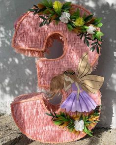 a pink letter decorated with flowers and a fairy