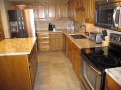 a kitchen with granite counter tops and wooden cabinets