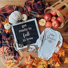 baby clothes, apples and pumpkins are laid out on a wooden table with the words we're adding a little apple to our family tree