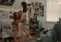 two girls in a dorm room with lights strung overhead