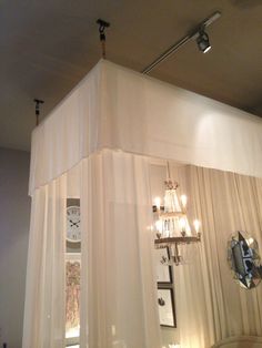 a room with curtains and chandeliers hanging from the ceiling