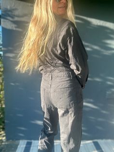 Amp up your style with our long sleeve utility jumpsuit! Made with a comfortable elastic waistband and featuring a button front, this jumpsuit is a perfect blend of fashion and function. The model, standing at 5'8" with measurements of 32-23-34, is seen wearing size S. Get ready to make a statement with our Top Shop jumpsuit! Fall Denim Overall Jumpsuit With Pockets, Utility Denim Jumpsuit With Pockets For Fall, Button-up Utility Bottoms For Fall, Utility Button-up Bottoms For Fall, Fall Utility Button-up Bottoms, Casual Cotton Button-up Jumpsuits And Rompers, Casual Long Sleeve Denim Jumpsuit, Casual Button Closure Overalls, Trendy Relaxed Fit Overalls For Loungewear