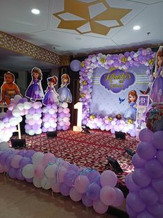 balloons are arranged on the floor in front of a stage set up for a princess birthday party