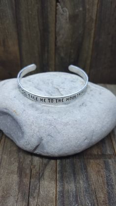 "Hand Stamped Bangle Bracelet stamped with the words \"Take Me to the Mountains\" along with mountain design stamps Lightweight Aluminum  6 inches length 1/4 inch width Can be adjusted to fit just about any wrist!!" Stamp Bracelet Ideas, Adjustable Stamped Meaningful Cuff Bracelet, Adjustable Stamped Meaningful Bracelet, Inspirational Adjustable Stamped Cuff Bracelet, Inspirational Stamped Adjustable Cuff Bracelet, Meaningful Adjustable Stamped Bracelets, Meaningful Adjustable Stamped Bracelet, Meaningful Stamped Adjustable Bracelet, Inspirational Adjustable Stamped Bracelets