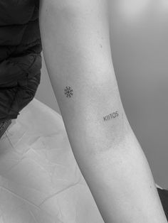 a black and white photo of a person's arm with the word tattoo on it