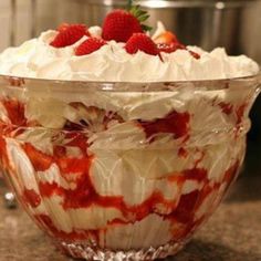 a dessert dish with strawberries and whipped cream in the center, sitting on a counter