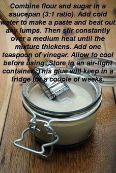 a jar filled with white liquid sitting on top of a wooden table next to a knife