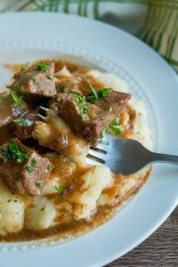 a white plate topped with meat and gravy