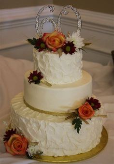 a three tiered wedding cake decorated with flowers and the number 50 on top is sitting on a gold platter