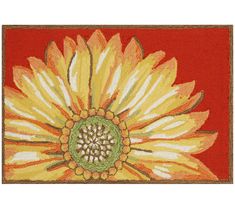 an orange and yellow rug with a flower on the center, in front of a red background