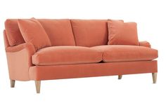 an orange couch sitting on top of a white floor