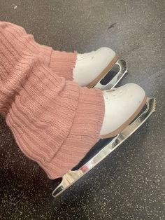 a pair of white shoes sitting on top of an ice skate