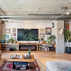 a living room filled with furniture and a flat screen tv mounted to the wall over a fire place