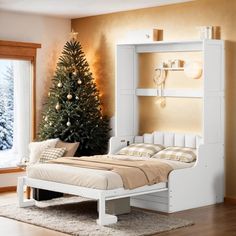 a white bed sitting next to a christmas tree