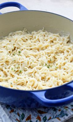 a blue pot filled with noodles on top of a table