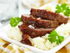 meatloaf with gravy and mashed potatoes on a white square plate