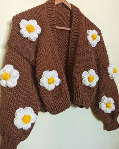 a brown sweater with white and yellow flowers on it