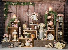 an arrangement of vases, candles and flowers on display in front of a wooden wall