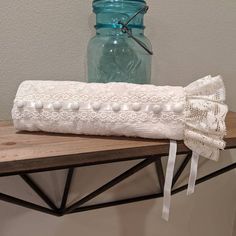 a white garter sitting on top of a wooden table next to a mason jar