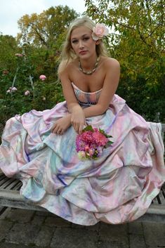 a woman in a dress sitting on a bench