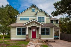 a house with green siding and red door