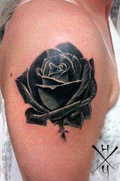 a black and white rose tattoo on the left upper half of her arm is shown