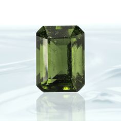 "Item Code: MF097 Metric Dimensions: 11 x 8 x 7 mm Imperial Dimensions: ½\" x ¼\" x ¼\" mm Weight: 4 Carats (0.8 grams) This one of a kind Emerald Cut Genuine Moldavite Facet is a collector's dream. It features a crisp cut to emphasize its beautiful color and sparkle, making it an extraordinary addition to any jewelry collection. Perfectly faceted for maximum brilliance, it will bring you a subtle yet luxurious radiance that's sure to make a statement." Moldavite Stone, Gemstone Properties, Emerald Gem, Star Magic, Blue Kyanite, Dream It, Amethyst Crystal, Emerald Cut, Sterling Silver Pendants